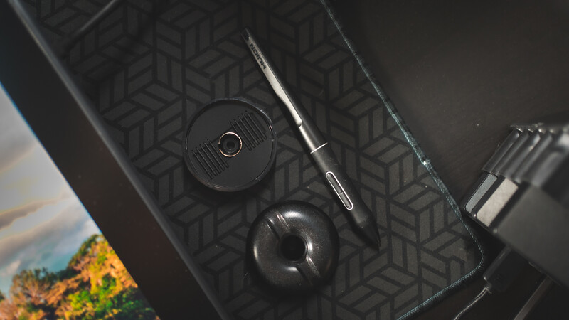 Close-up of camera lens and mechanical controls on dark textured surface.