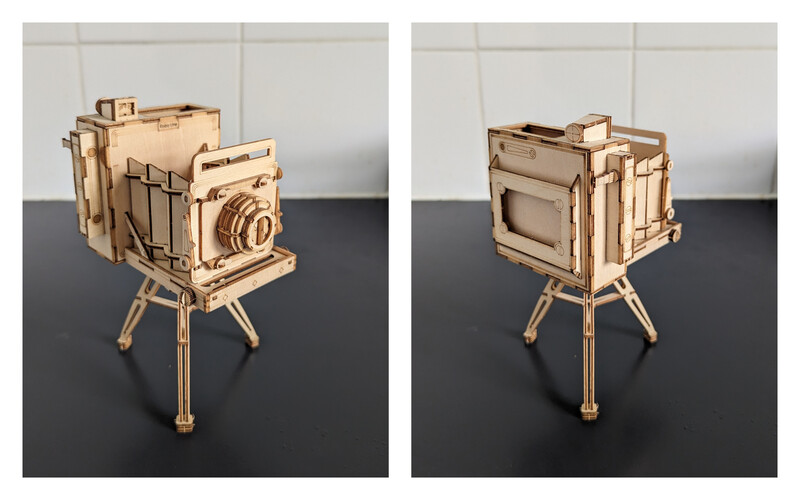 Wooden model of a large format camera on tripod, shown from front and back views.