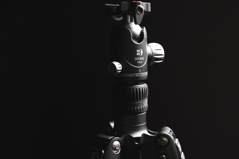 Professional tripod head with ball joint and panoramic rotation controls mounted on dark background.