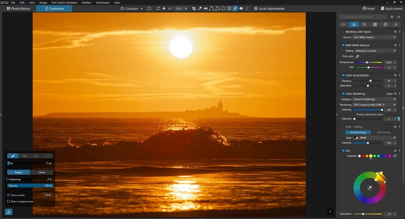 Golden hour sunset over ocean with silhouetted landscape and bright sun reflecting on water.