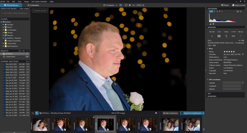 Man in blue suit and light blue shirt with boutonniere, photographed in profile against blurred gold bokeh backdrop.