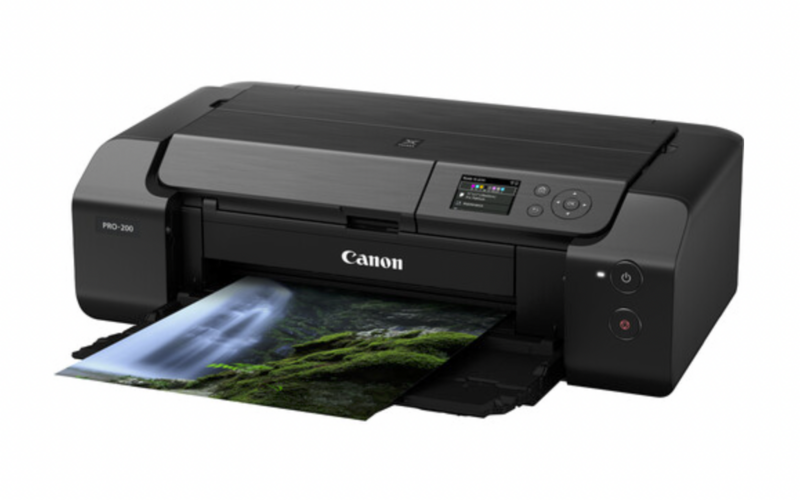 Canon PRO-300 inkjet printer with photo paper output showing landscape imagery.