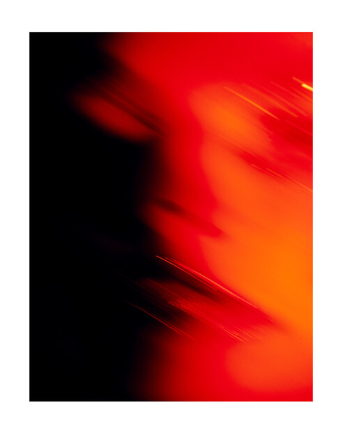 Abstract gradient with sharp diagonal light streaks transitioning from black to red and orange.