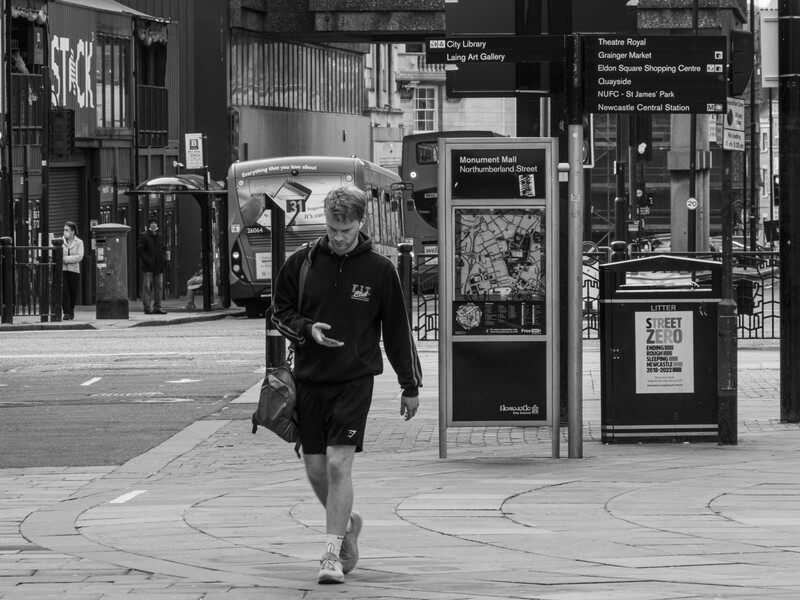 Runner jogging through urban plaza in black and white street photography.