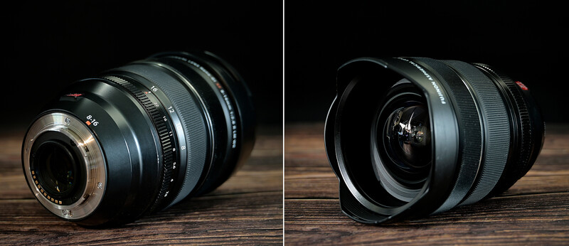 Two camera lenses photographed from rear and front angles against a dark wooden surface and black background.