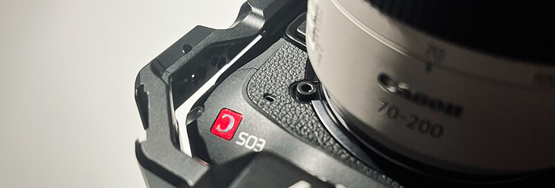 Close-up of a camera body showing a red indicator button labeled 502 on the textured grip area.