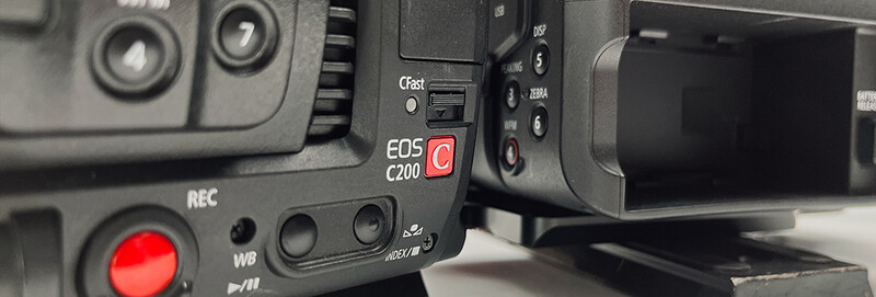 Canon EOS C200 cinema camera body with control panel visible, showing red record button and LCD monitor on right side.