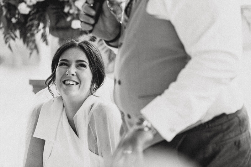 Woman in white blouse smiling at man in white dress shirt during an intimate moment.