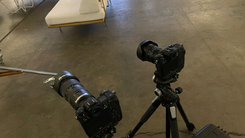 Two professional video cameras mounted on tripods in an indoor studio space.