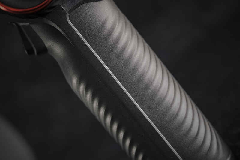 Close-up of a microphone windscreen with textured foam wrapping and a thin silver trim line.