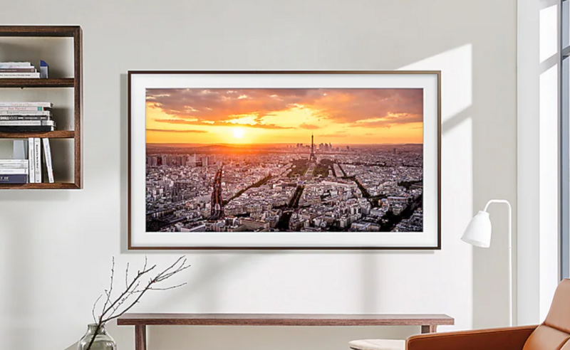 Framed cityscape photograph displaying a golden sunset over an urban skyline with cathedral visible in center.