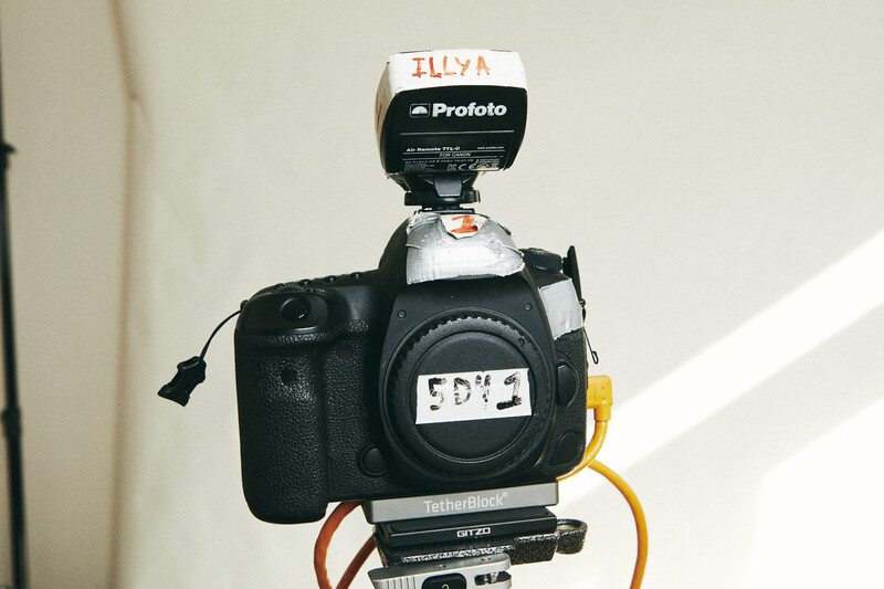 Profoto flash unit mounted on camera body with lens attached, studio setup detail.