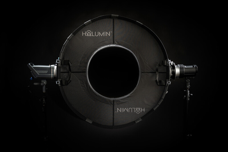 Circular lighting rig with central aperture and dual fixtures mounted symmetrically on sides.