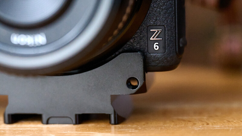 Nikon Z6 camera body with Z-mount lens attached, showing the camera's top plate and lens barrel on a wooden surface.