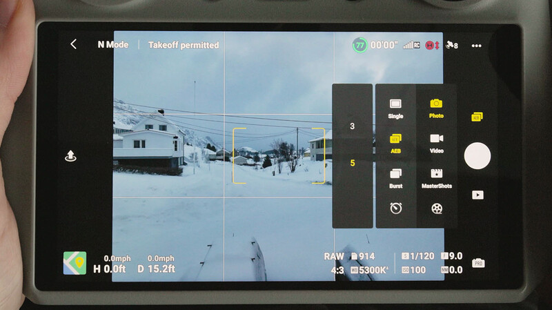 Screenshot of camera app interface showing snowy street scene with grid overlay and RAW settings panel.