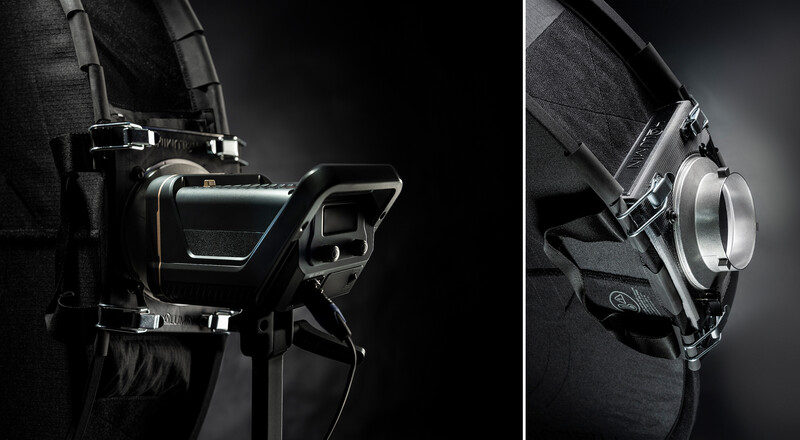 Professional headphones mounted on a black fabric surface, shown from two angles in dramatic side lighting.