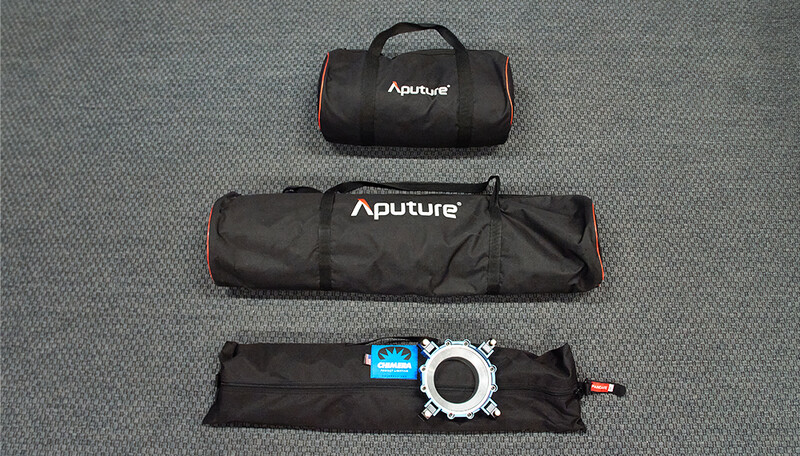 Three Aputure equipment cases and a lighting modifier displayed on gray fabric.