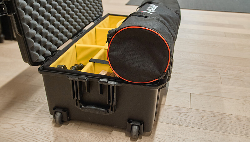 Hard case with foam insert and black cylindrical lens case with red trim inside.