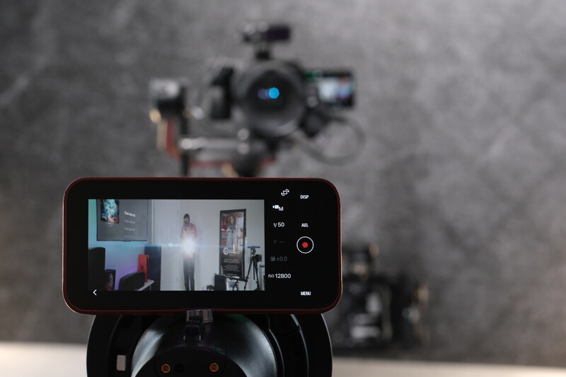Smartphone mounted on a gimbal displaying live video feed with multiple camera angles and recording controls.
