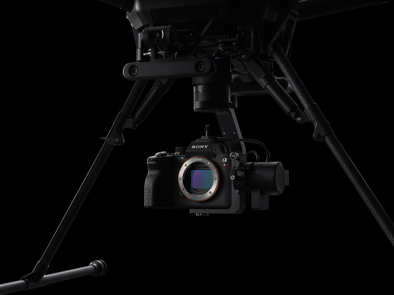 Sony mirrorless camera mounted on a gimbal stabilizer against a black background.