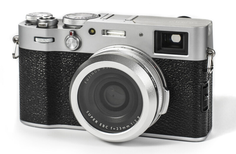 Rangefinder camera with silver top plate and black textured body, featuring a fixed lens and optical viewfinder.
