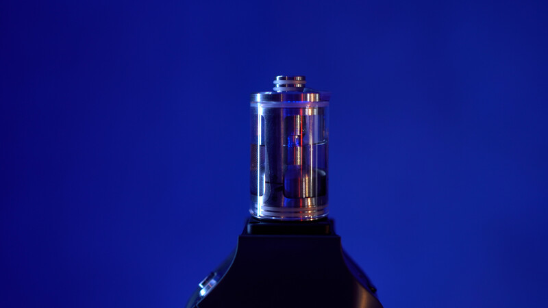 Glowing vacuum tube against deep blue background with dramatic lighting.