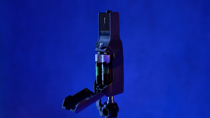 Professional camera flash unit with articulating head mounted on stand against blue background.