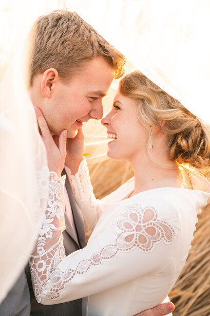 Man and woman facing each other in close embrace with warm, golden-hour lighting.