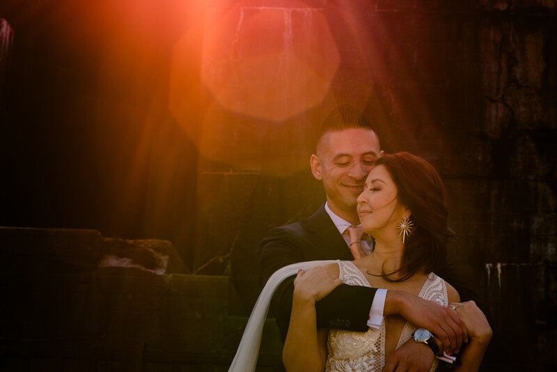 Couple embracing under warm golden stage lighting during an indoor event.