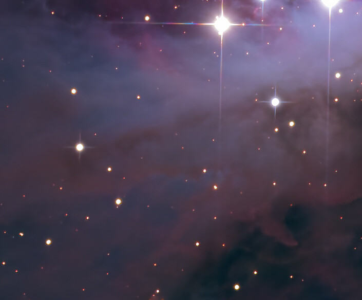 Deep space nebula with scattered stars and diffraction spikes from bright stellar objects.