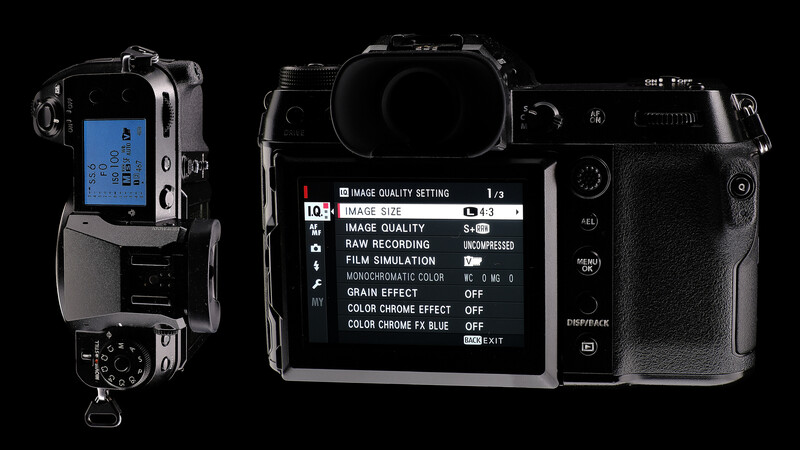 Mirrorless camera displaying menu settings on rear LCD screen and top control panel against black background.