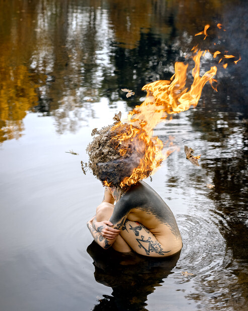 Nude woman in lake with her hair on fire.