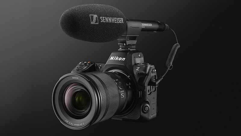 Nikon Z camera with Sennheiser microphone mounted on top against dark background.