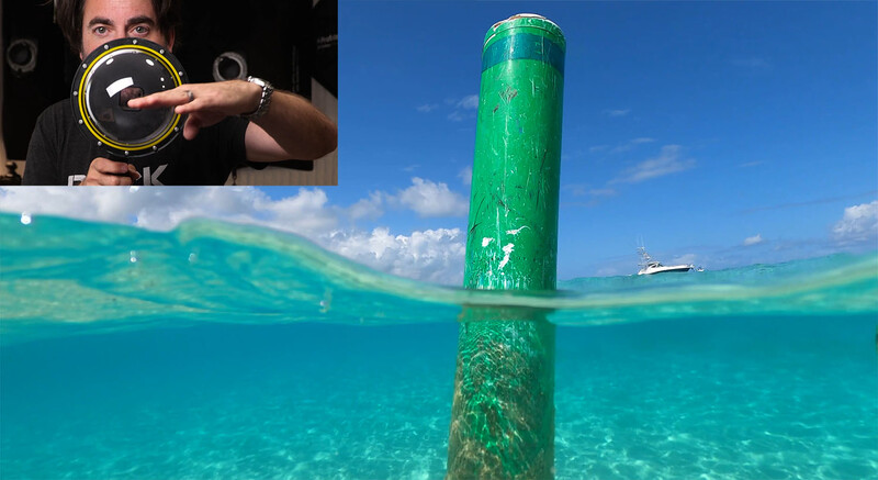 Split-level underwater photograph showing a green mooring buoy half-submerged in turquoise water with a boat visible in the distance, and inset image of photographer holding an underwater camera lens.