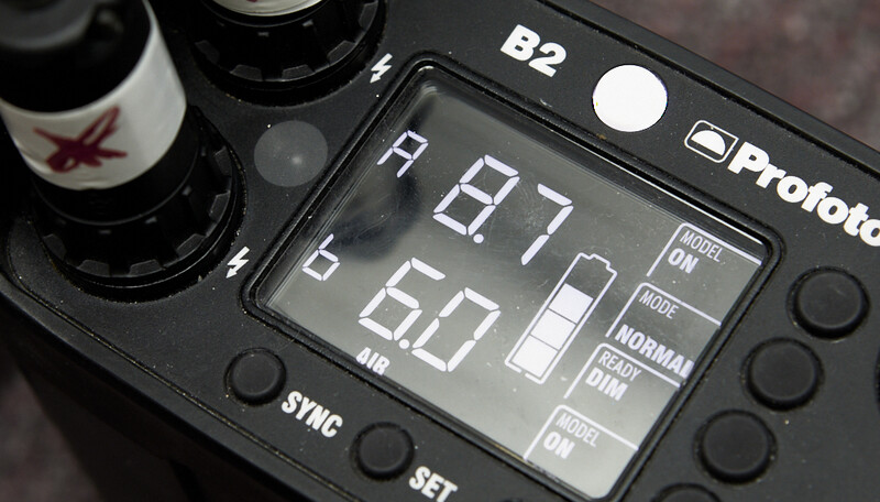 Profoto B2 flash unit displaying settings on its LCD screen showing 5.7 flash output and 50 power level.