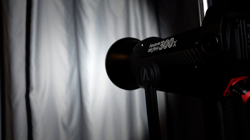 Studio lighting setup with a monolight featuring a 500-watt indicator, positioned against a white diffusion panel.