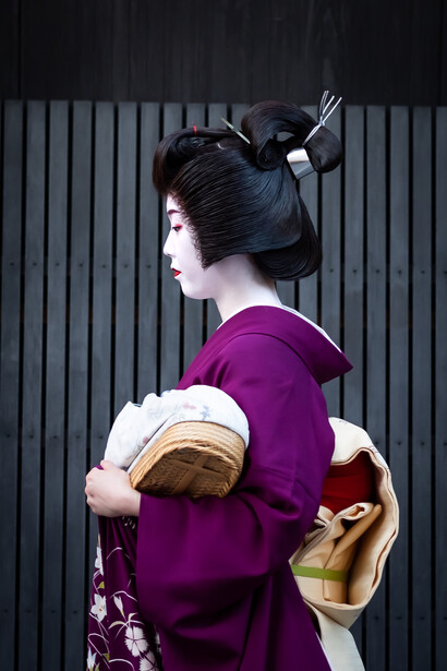 A geisha walks the busy streets of Gion in Kyoto, Japan
