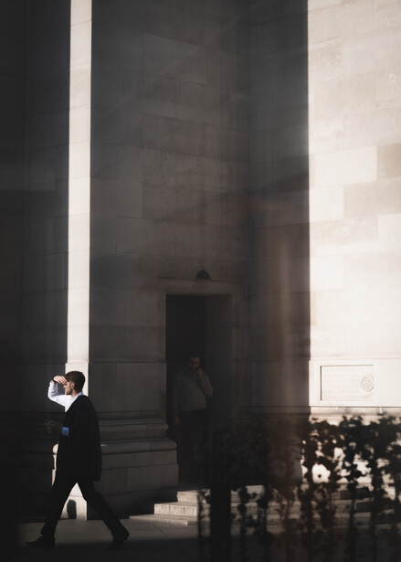 A man steps into the bright daylight of London on his way through Covent Garden