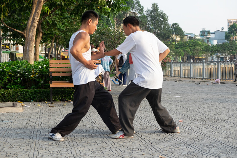 Two men practise martial arts at a public park in Ho Chi Minh City, Vietnam