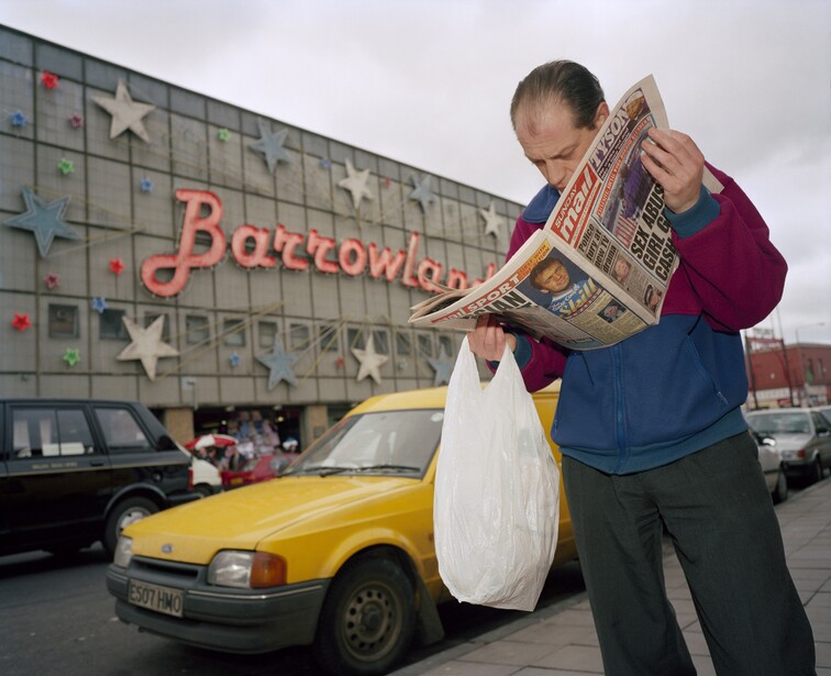A man stops to read a newspaper article whilst walking past the Barrowland Ballroom in Glasgow.