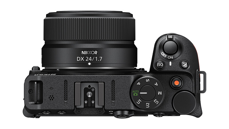 Top-down view of a mirrorless camera body with DX 24/1.7 lens and control dial visible.