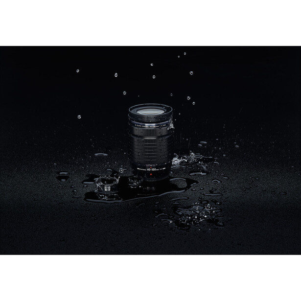 Camera lens and DSLR body surrounded by splashing water droplets against a black background.
