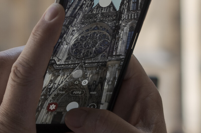 Smartphone displaying detailed black and white architectural photograph of a cathedral facade with rose window.