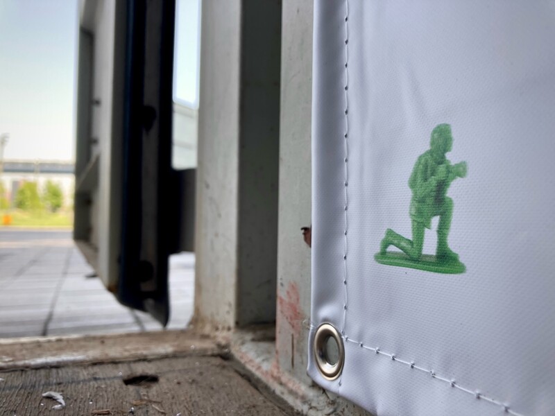 Green sticker of a standing figure on the exterior wall of a white RV or camper.
