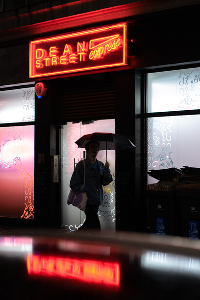 An unprocessed image of someone with an umbrella walking in the rain