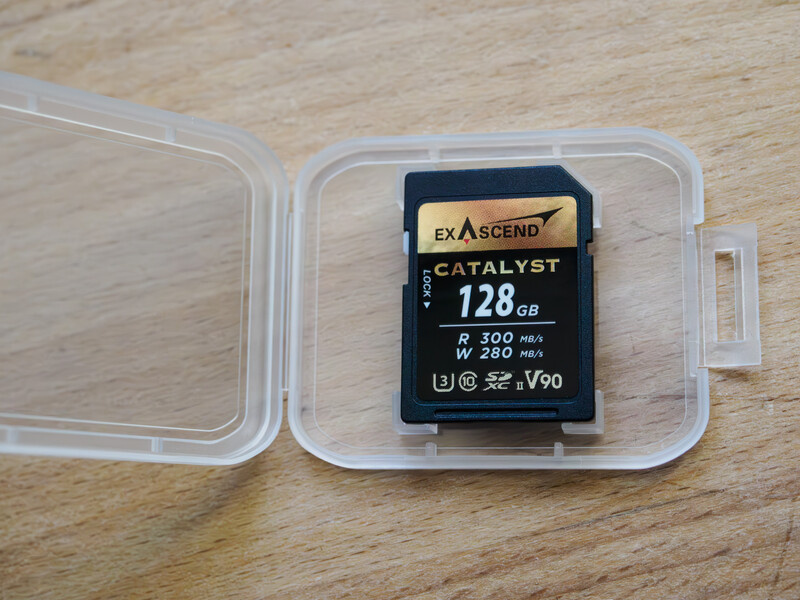 Exascend Catalyst 128GB SD card in clear plastic case on wooden surface.