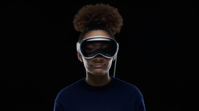 Person wearing a white VR headset against a black background, looking directly at camera.