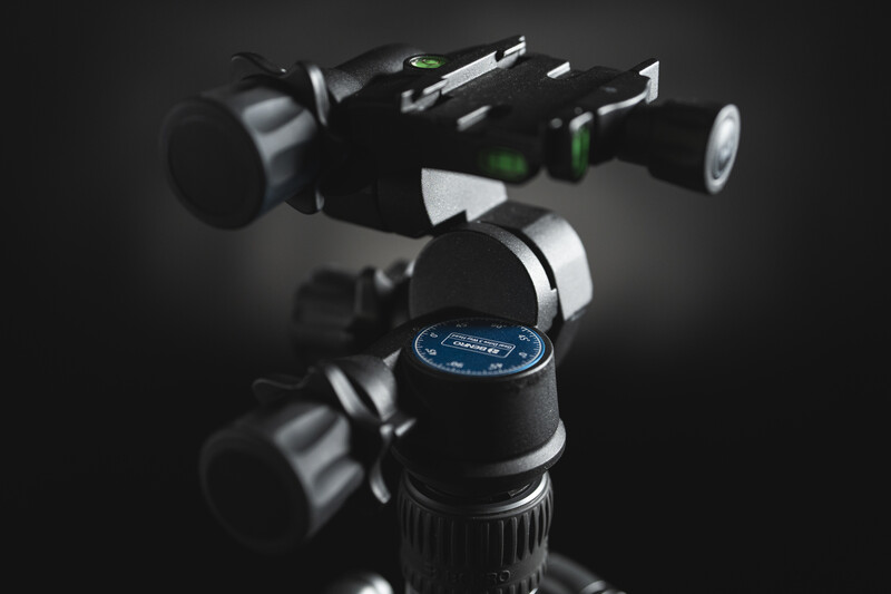 Professional tripod head with ball mount and adjustable pan-tilt controls, shown against dark background.