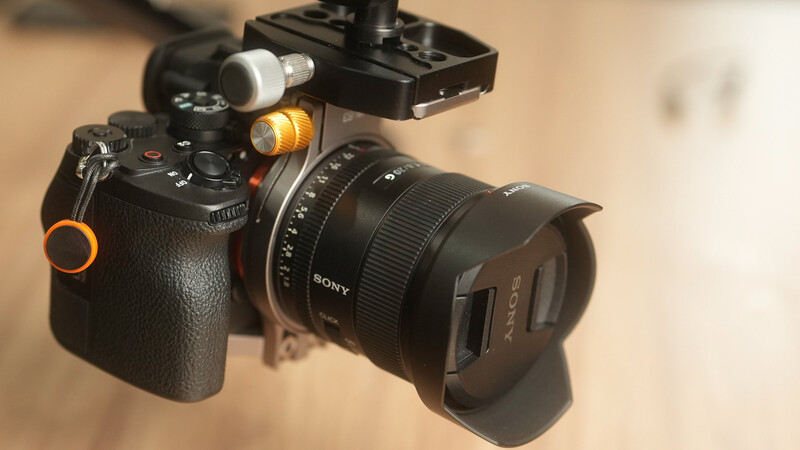 Sony mirrorless camera with telephoto lens and mounted LED light fixture on hot shoe.