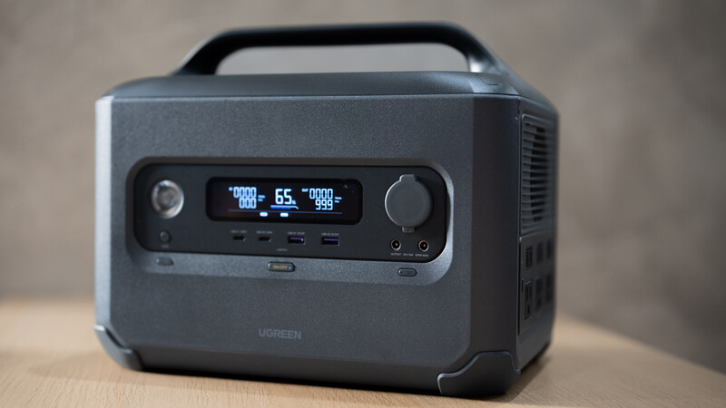 Portable power station with digital display showing wattage and battery percentage readings.